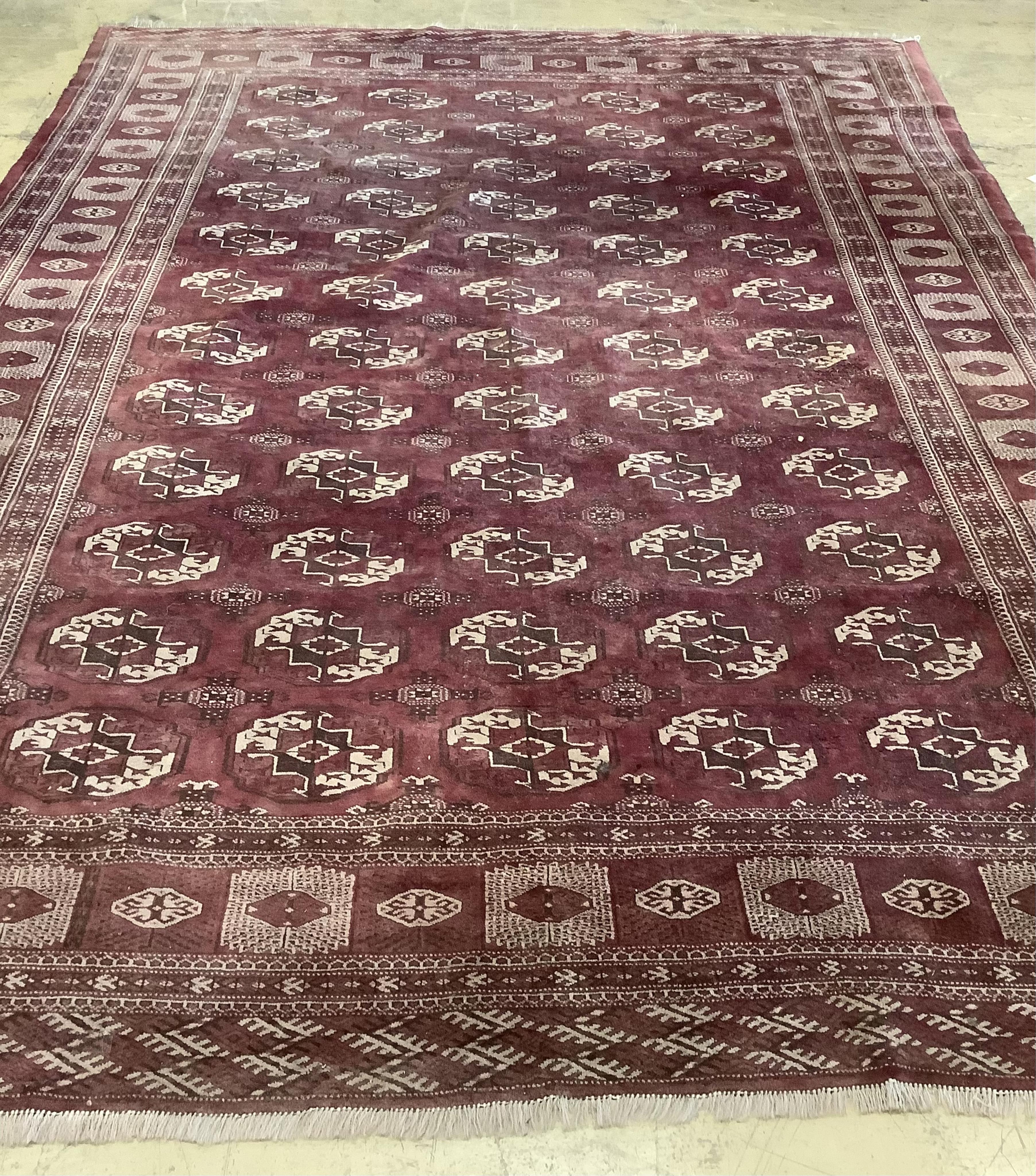 An antique Bokhara carpet, 384 x 286cm. Condition - fair